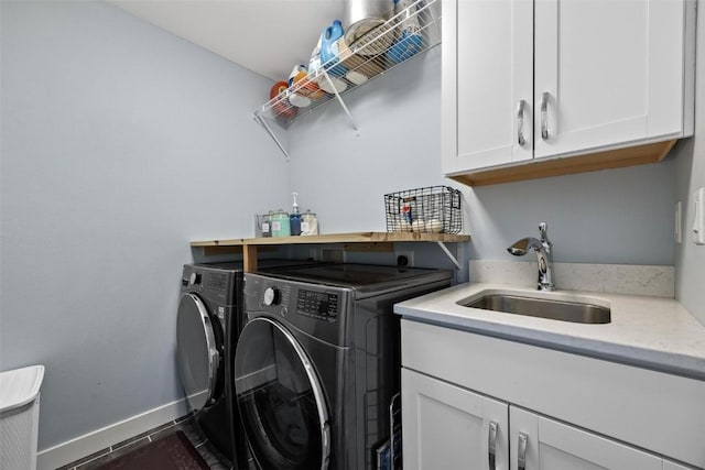 laundry area featuring sink, washer and clothes dryer, and cabinets