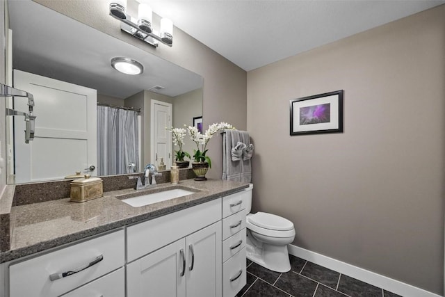 bathroom featuring toilet, tile patterned floors, and vanity