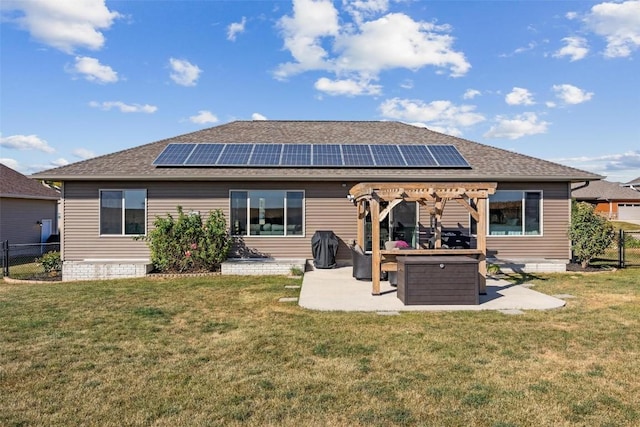 back of house featuring a pergola, a patio area, a yard, and solar panels