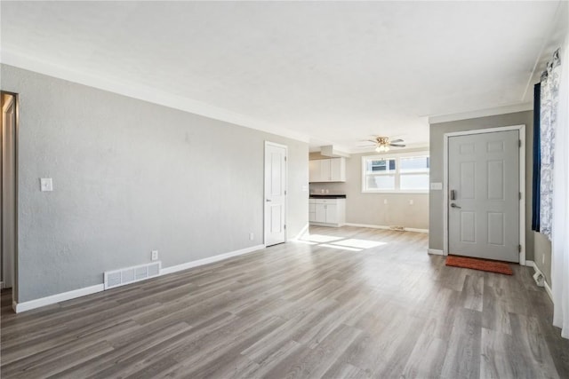 unfurnished living room with hardwood / wood-style floors, ceiling fan, and ornamental molding