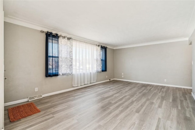 empty room featuring light hardwood / wood-style floors and crown molding