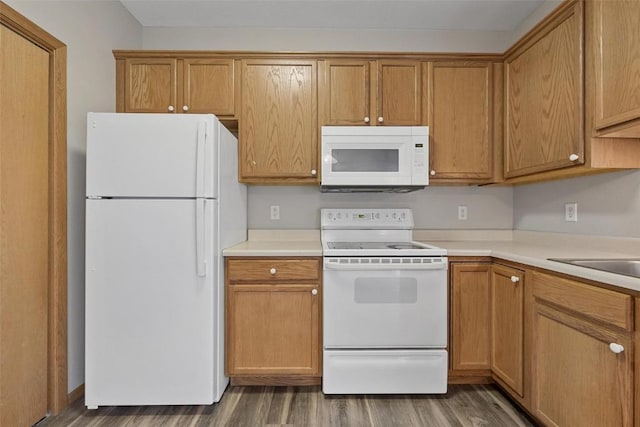 kitchen with sink, white appliances, and dark wood-type flooring