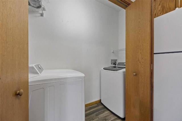 laundry area featuring washing machine and clothes dryer and dark wood-type flooring