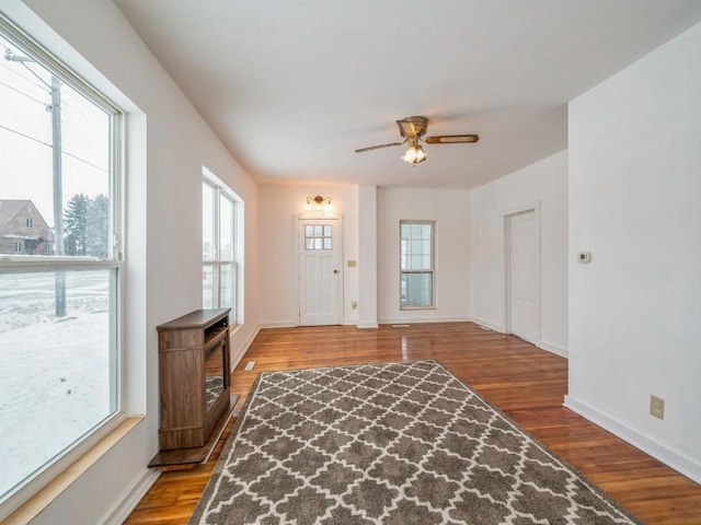 interior space with light wood-type flooring, ceiling fan, and a wealth of natural light