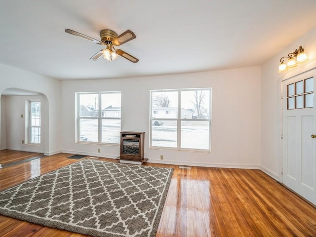 unfurnished living room featuring ceiling fan and hardwood / wood-style floors