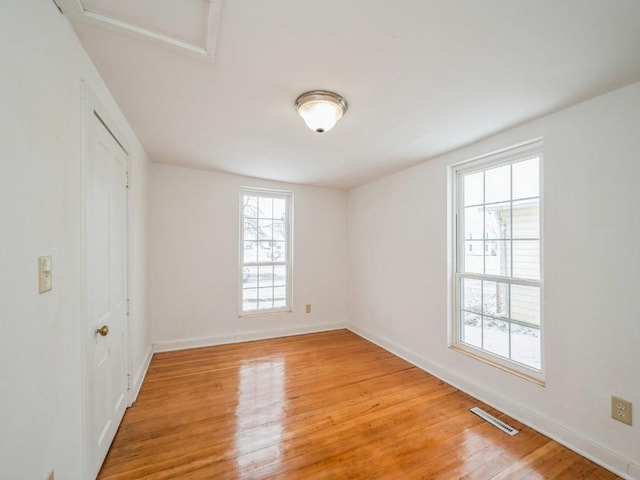 spare room with hardwood / wood-style flooring and plenty of natural light