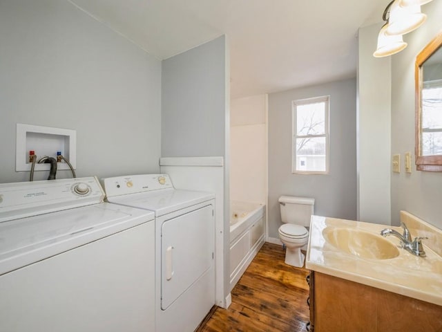 clothes washing area featuring washer and dryer, sink, and dark hardwood / wood-style floors