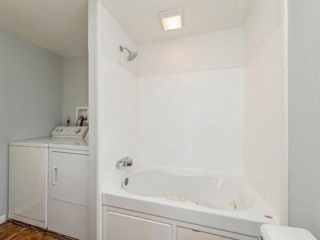 bathroom featuring a washtub, wood-type flooring, and independent washer and dryer