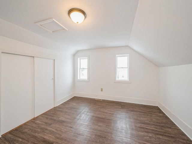 bonus room featuring vaulted ceiling and dark wood-type flooring