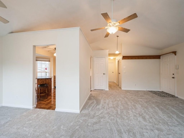 carpeted spare room with ceiling fan, crown molding, and vaulted ceiling