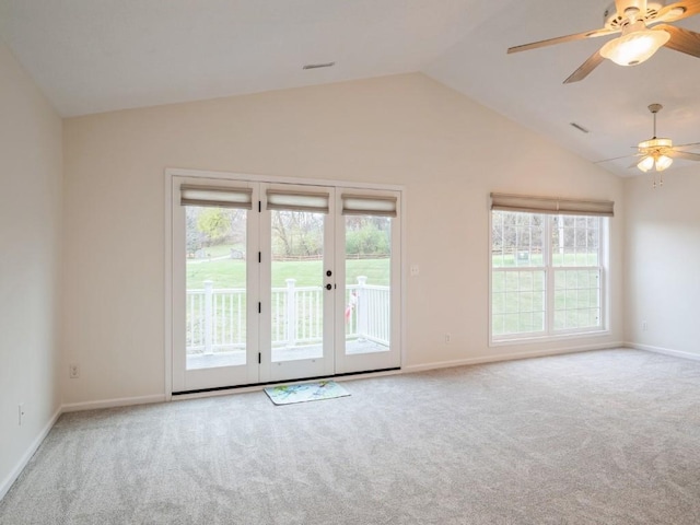 carpeted spare room featuring ceiling fan, lofted ceiling, and french doors