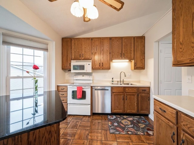 kitchen with white appliances, dark parquet flooring, sink, vaulted ceiling, and ceiling fan