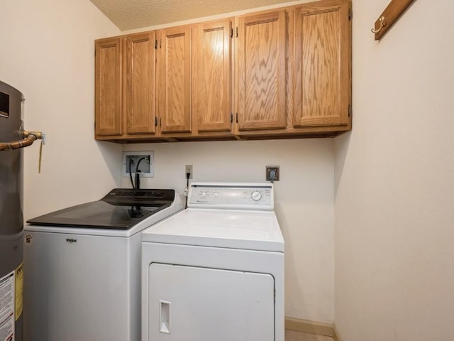 washroom with cabinets, a textured ceiling, washer and dryer, and water heater