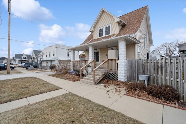 view of front of house with covered porch and a front lawn