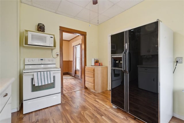 kitchen featuring white appliances, light hardwood / wood-style flooring, ceiling fan, and a paneled ceiling