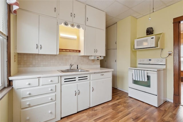 kitchen featuring a paneled ceiling, tasteful backsplash, sink, white cabinets, and white appliances