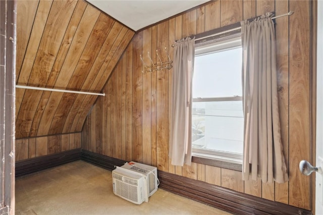 bonus room with lofted ceiling, an AC wall unit, and wood walls