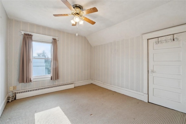 interior space with baseboard heating, ceiling fan, lofted ceiling, and carpet floors