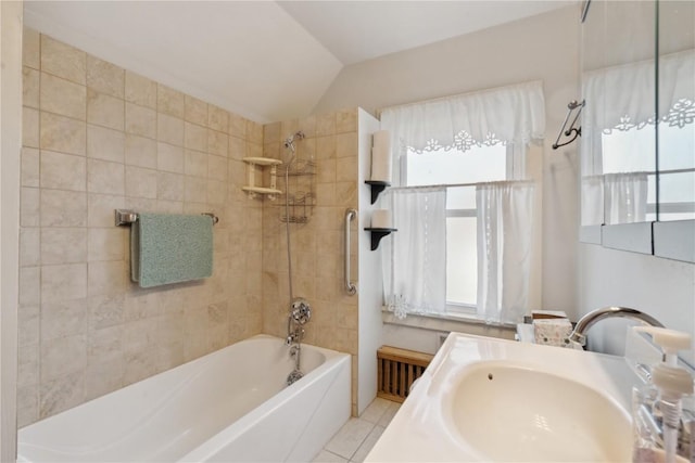 bathroom featuring lofted ceiling, tile patterned floors, tiled shower / bath combo, and vanity