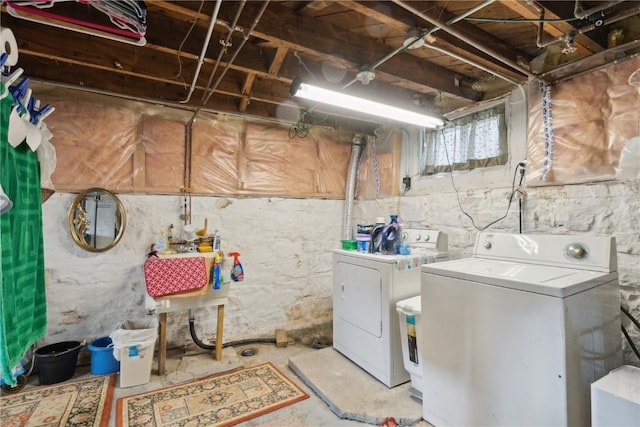 laundry area with separate washer and dryer and sink