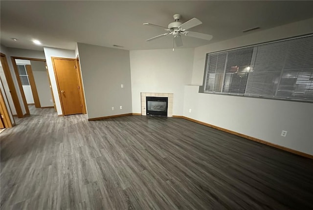 unfurnished living room with ceiling fan, hardwood / wood-style floors, and a tile fireplace