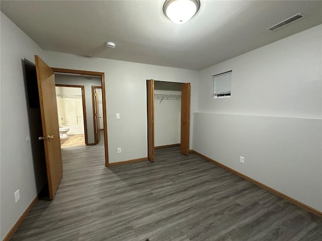 unfurnished bedroom featuring dark hardwood / wood-style floors and a closet