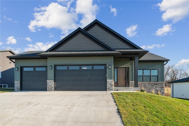 craftsman house featuring a garage and a front lawn