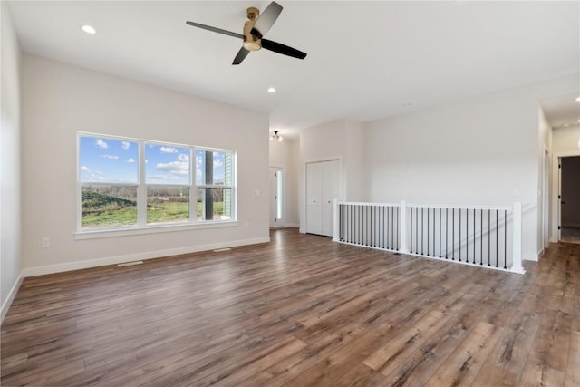 spare room with hardwood / wood-style flooring, vaulted ceiling, and ceiling fan