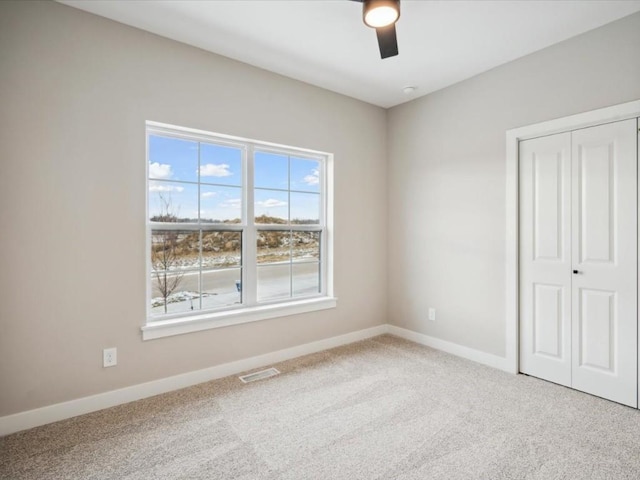 unfurnished bedroom featuring ceiling fan, carpet floors, and a closet