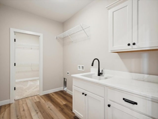 clothes washing area with sink, cabinets, washer hookup, hookup for an electric dryer, and light wood-type flooring