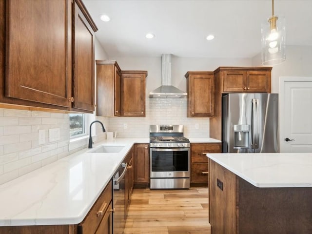 kitchen featuring stainless steel appliances, tasteful backsplash, sink, and wall chimney range hood