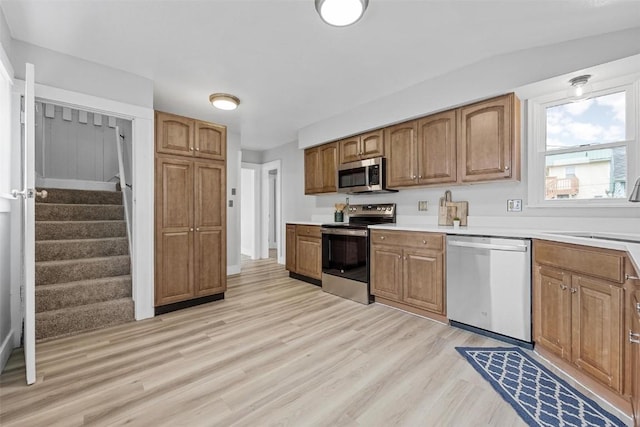 kitchen with sink, light wood-type flooring, and appliances with stainless steel finishes