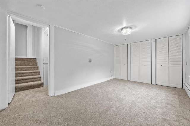 unfurnished bedroom featuring multiple closets and light carpet