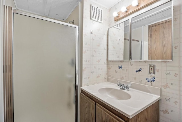 bathroom featuring vanity and a shower with door