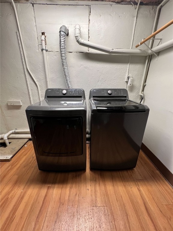 clothes washing area featuring hardwood / wood-style flooring and separate washer and dryer