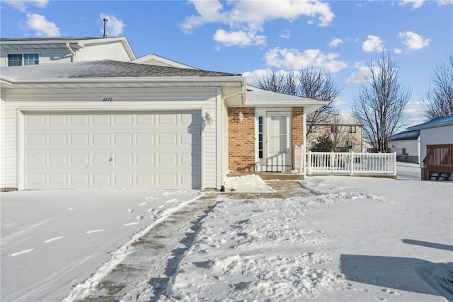 view of snowy exterior featuring a garage