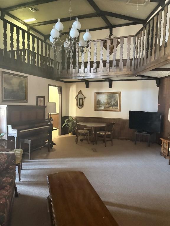 living room with an inviting chandelier, carpet floors, and a high ceiling