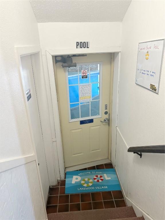 doorway to outside featuring a textured ceiling