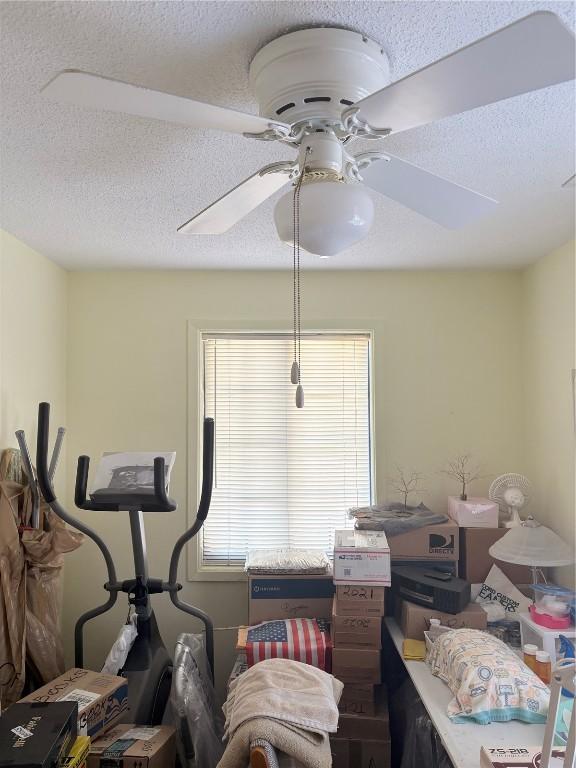 interior space with a textured ceiling and ceiling fan