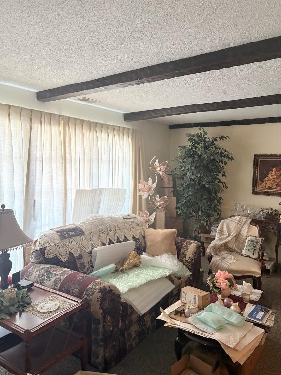 living room with a textured ceiling and beamed ceiling