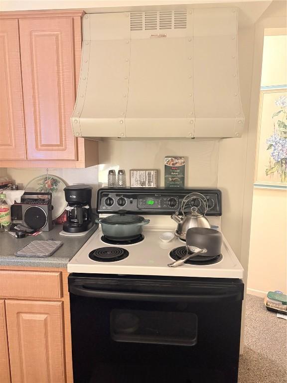 kitchen featuring light brown cabinetry and electric range oven