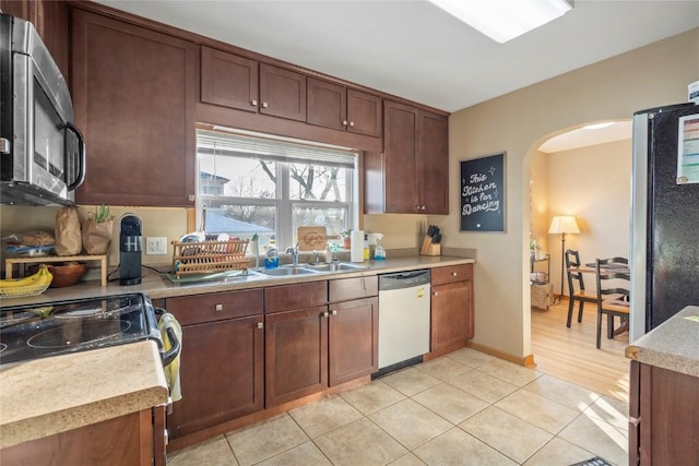 kitchen with sink, light tile patterned floors, and appliances with stainless steel finishes