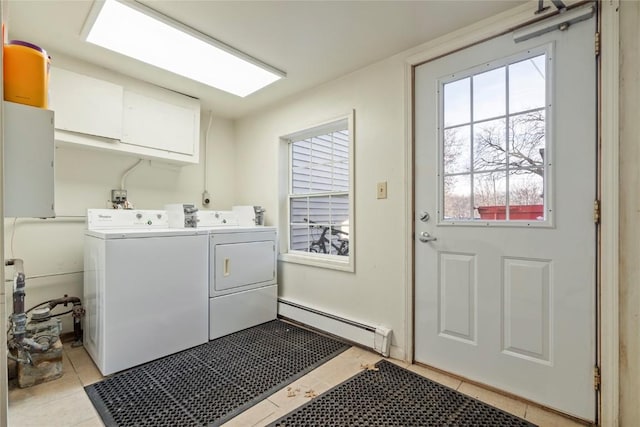 clothes washing area with separate washer and dryer, cabinets, light tile patterned floors, baseboard heating, and plenty of natural light