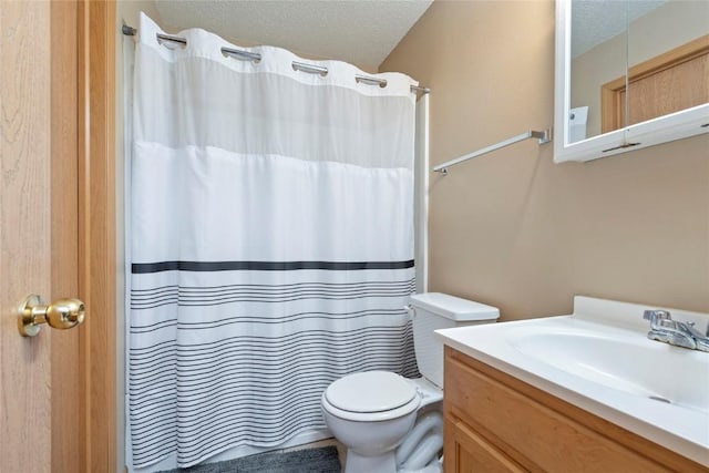 bathroom with vanity, toilet, and a textured ceiling