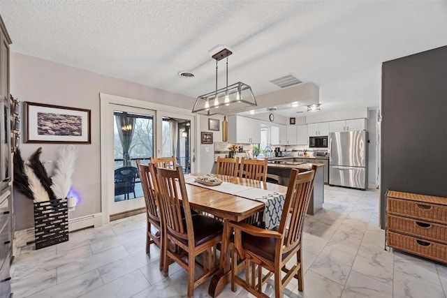 dining room with baseboard heating and a textured ceiling