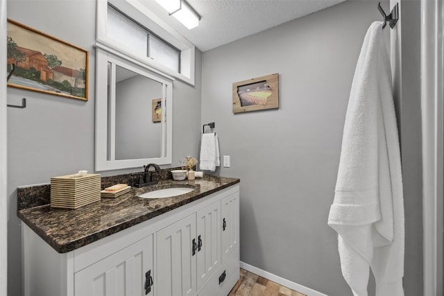 bathroom featuring hardwood / wood-style flooring, vanity, and a textured ceiling