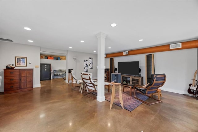 living room featuring concrete flooring and decorative columns