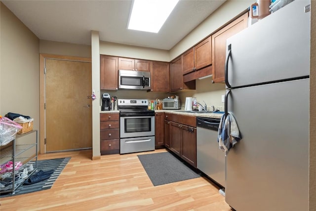 kitchen featuring sink, stainless steel appliances, and light hardwood / wood-style floors