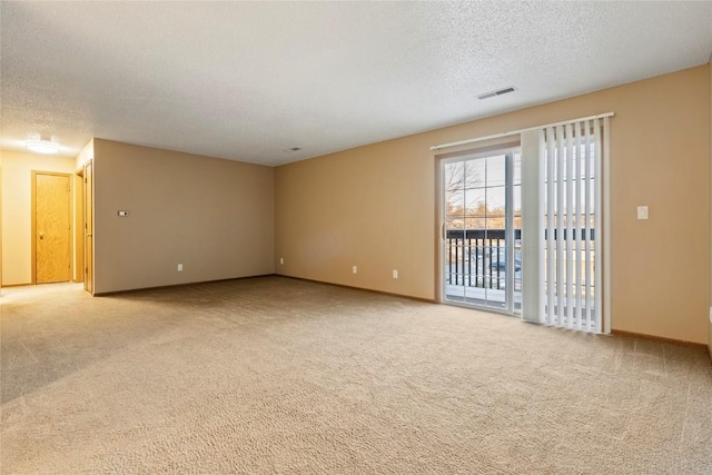 carpeted spare room with a textured ceiling