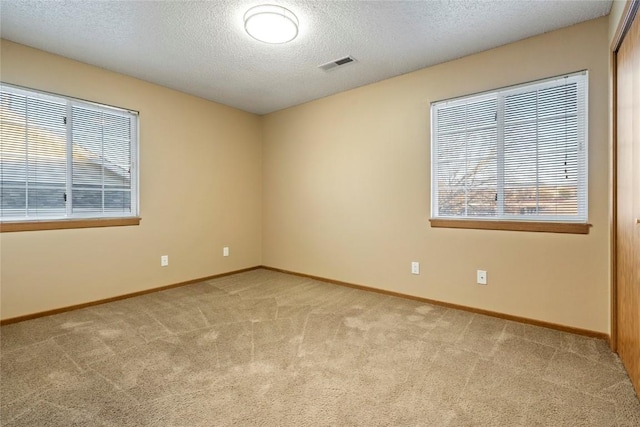 empty room featuring light carpet and a textured ceiling